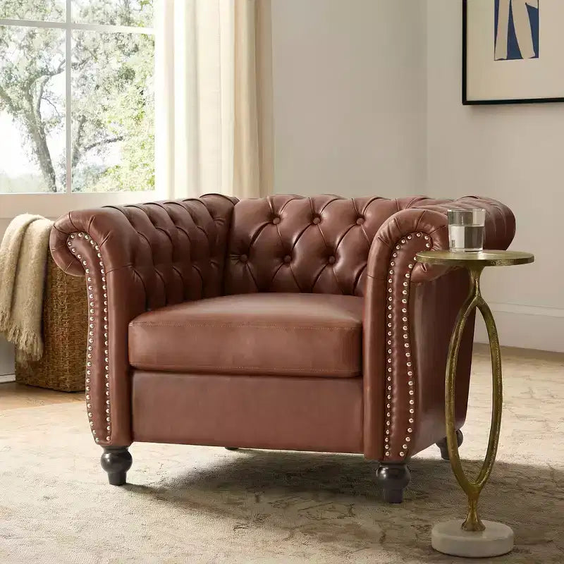Poltrona Chesterfield Club con braccioli arrotolati, borchie e gambe in legno massello